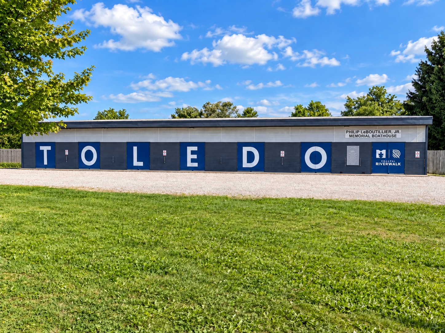 The Philip LeBoutillier Jr. Memorial Boathouse with TOLEDO painted across its blue bay doors